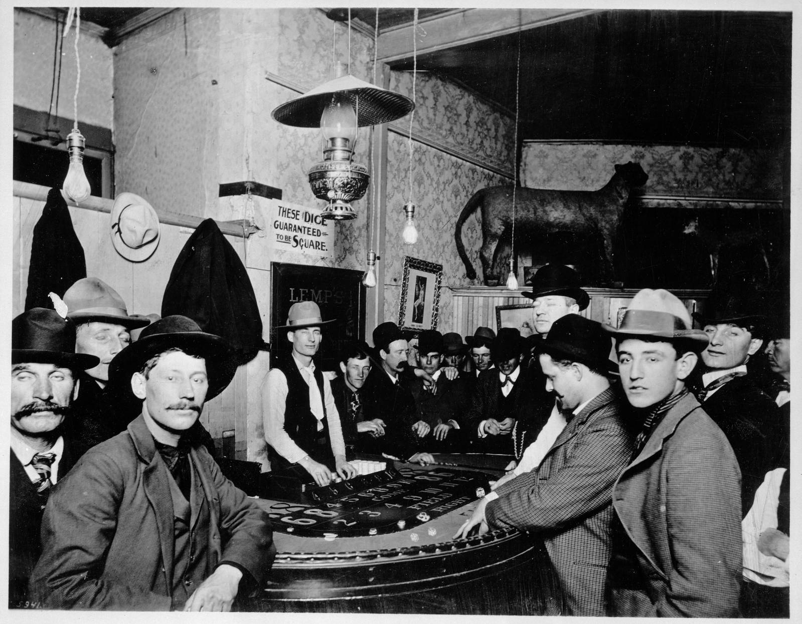 Men gathered around a dice game in an early American saloon